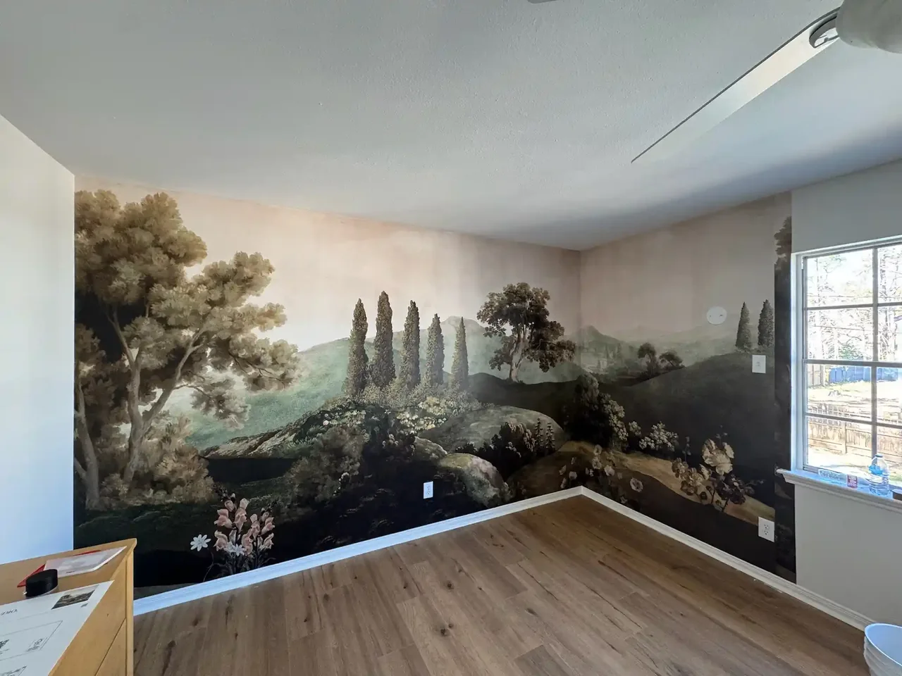 A panoramic nature mural across a bright room wall